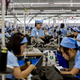In this Sept. 29, 2015 photo, workers in the Great Forever factory stitch clothes in the Hlaing Tharyar industrial zone outside Yangon, Myanmar. After decades of isolation and underdevelopment, the lack of even basic industries means apparel makers must import everything they use to make garments: thread, cloth, zippers, buttons. (AP Photo/Gemunu Amarasinghe)